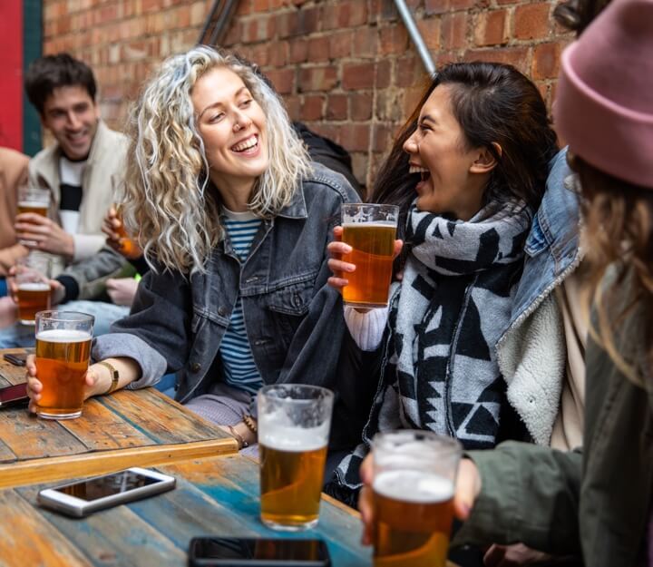 Friends enjoying a drink together while playing Treasure Hunt Manchester