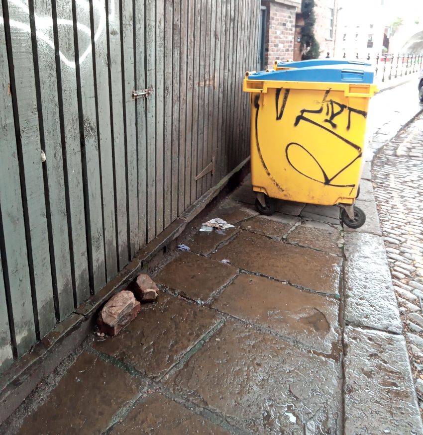 A large bin blocking the pavement.